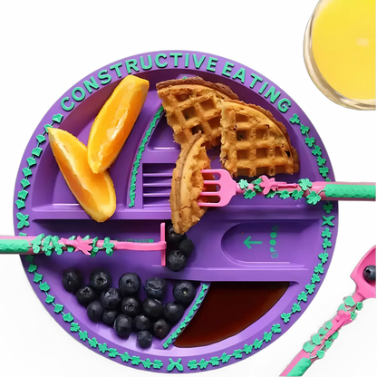 Menino se alimentando com utensílios de construção divertidos